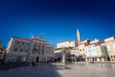PIRAN, SLOVENIA - SEPTEMBER 17, 2021: Panorama of of the Piazza Tartini square of Piran, slovenia, with a focus on the parish church of saint george, or zupnjiska cerkev svetog jurija, a major landmark of istria