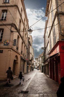 BORDEAUX, FRANCE - 19 Şubat 2022: insanlar, yayalar, karanlık bir sokakta yürüyorlar, dar, Bordeaux, Fransa şehir merkezinde. Bu binalar tipik Güneybatı Fransız mimarisidir.