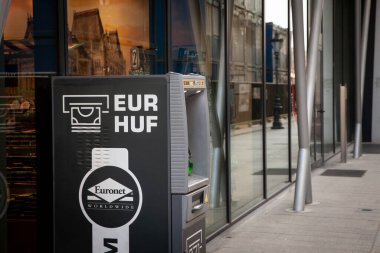 BUDAPEST, HUNGARY - FEBRUARY 27, 2022:  ATM changing & distributing money in Hungarian currency, the Hungarian Forint, HUF and European currency, the Euro, EUR, depending on current exchange rate