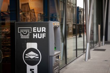 BUDAPEST, HUNGARY - FEBRUARY 27, 2022:  ATM changing & distributing money in Hungarian currency, the Hungarian Forint, HUF and European currency, the Euro, EUR, depending on current exchange rate clipart