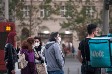 BELGRADE, SERBIA - MAY 24, 2021: Selective blur on tourists young girls and older man walking in Belgrade wearing face mask respiration protective equipement on Coronavirus Covid 19 crisis