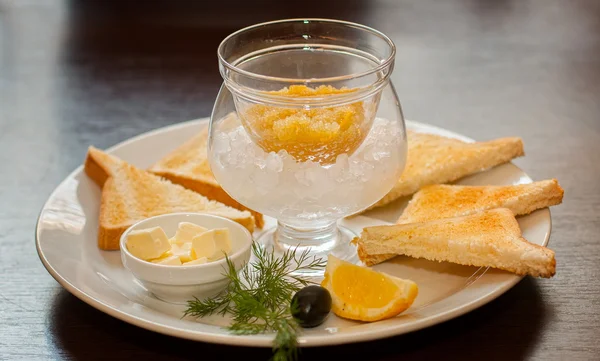 在冰上油和面包切片一根长矛的鱼子酱 — 图库照片