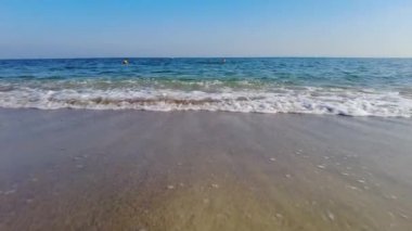 Parlak güneşli bir günde deniz kıyısı ve mavi gökyüzü yavaş çekimde
