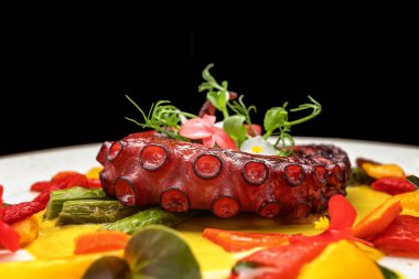 Pişmiş ahtapot dokunaçlarını otlarla kapatın.