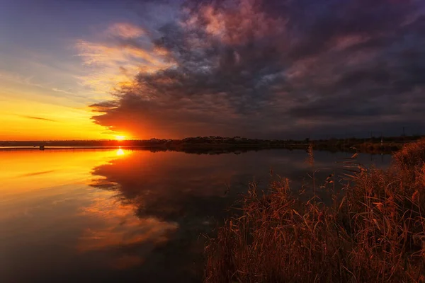Schöner Sonnenuntergang am See mit Wolken und Spiegelungen im Wasser — Stockfoto