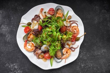 Deniz ürünleri karidesi, istiridye, ahtapot, kalamar, domates ve marul ile karıştırın.