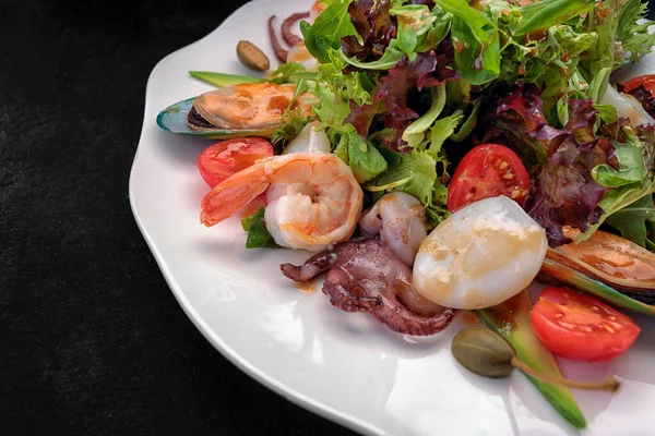 Deniz ürünleri karidesi, istiridye, ahtapot, kalamar, domates ve marul ile karıştırın.