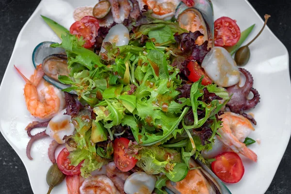 Deniz ürünleri karidesi, istiridye, ahtapot, kalamar, domates ve marul ile karıştırın.