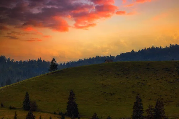 Sunset in the mountains hillside houses, mountain range and meadow. Carpathians — стокове фото