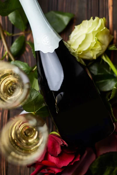 Ένα μπουκάλι κρασί, σαμπάνια, λουλούδια και δύο ποτήρια σαμπάνια. — Φωτογραφία Αρχείου