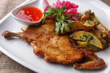 Patates ve baharatlı soslu kızarmış tavuk.