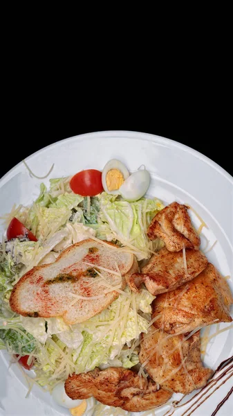 Salada com filé de frango, ovos, em um fundo preto com espaço para texto — Fotografia de Stock