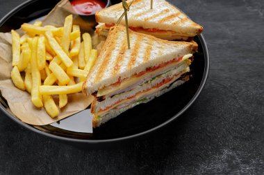 Jambonlu, domatesli, peynirli ve patates kızartmalı sandviçler.