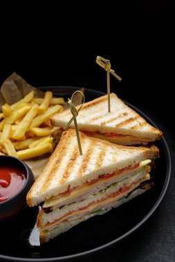 Jambonlu, domatesli, peynirli ve patates kızartmalı sandviçler.