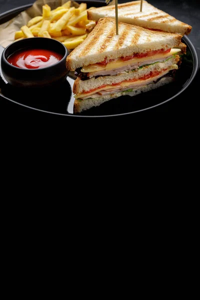 Бутерброди з шинкою, помідорами та сиром та картоплею фрі, з місцем для тексту на темному фоні — стокове фото