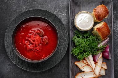 Donutlu Ukrayna çorbası, ekşi krema, domuz yağı ve dereotu, koyu arka planda.