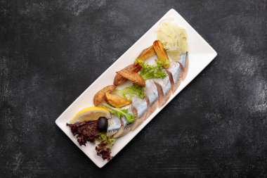 Fırında patates, soğan ve marullu ringa turşusu.