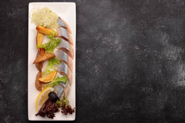 Fırında patates, soğan ve marullu ringa turşusu.