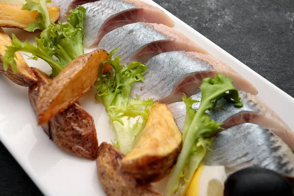 Fırında patates, soğan ve marullu ringa turşusu.