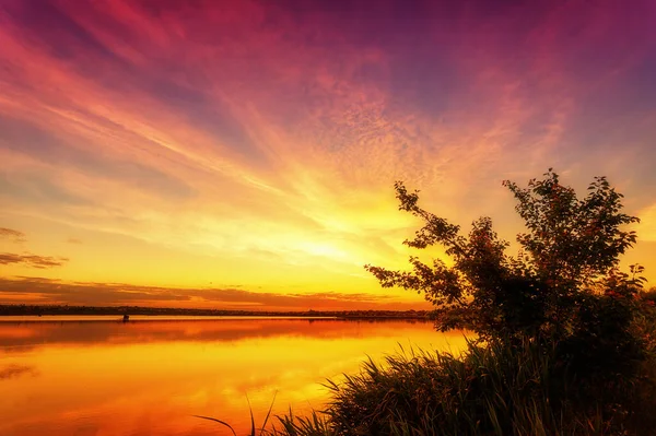 手前の雲と水が美しい夕日 — ストック写真