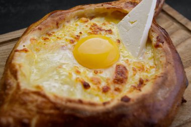 Adjarian Khachapuri Ahşap bir tahtada, karanlık bir arka planda
