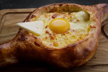 Adjarian Khachapuri Ahşap bir tahtada, karanlık bir arka planda
