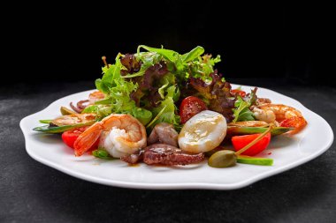 Deniz ürünleri karidesi, istiridye, ahtapot, kalamar, domates ve marul ile karıştırın.