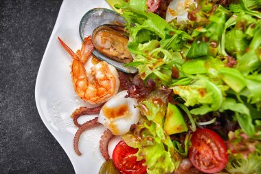 Deniz ürünleri karidesi, istiridye, ahtapot, kalamar, domates ve marul ile karıştırın.