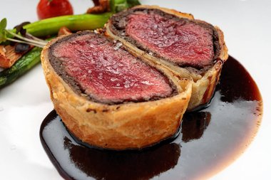 Mantarlı sığır eti, kuşkonmaz ve siyah arka planda baharatlı Razmarin soslu siyah mantar.