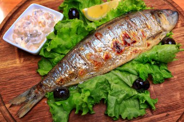 Kızarmış ringa, soslu ve limonlu, marul yaprağında.