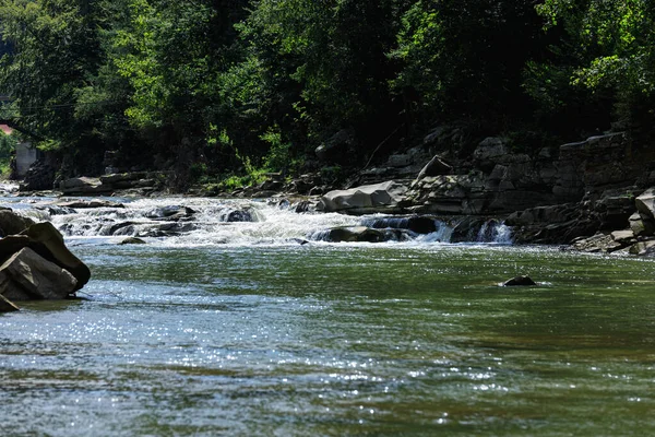 Горная река с порогами и большими камнями в солнечный день — стоковое фото