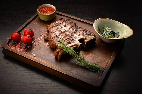 Filete T-Bone con salsa, sobre una tabla de madera — Foto de Stock