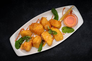 Peynirli nugget. Nane ve reçel, bir tabakta, karanlık bir arka planda.