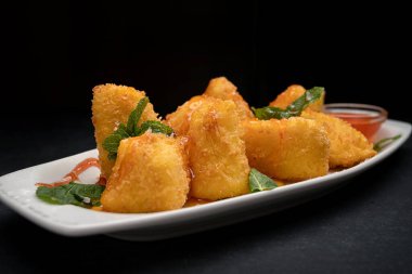 Peynirli nugget. Nane ve reçel, bir tabakta, karanlık bir arka planda.