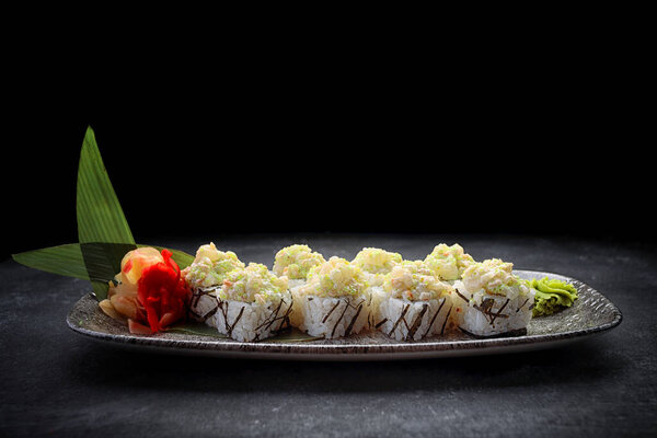 Sushi roll Volcano, with wasabi and ginger, on a plate