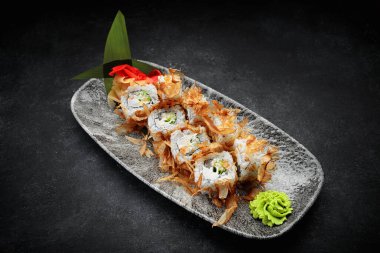 Suşi, Bonito 'yu koyu bir arka planda yuvarlıyor.