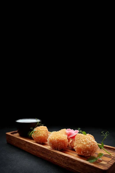 Camembert fries with sauce on a wooden board, on a dark background —  Fotos de Stock