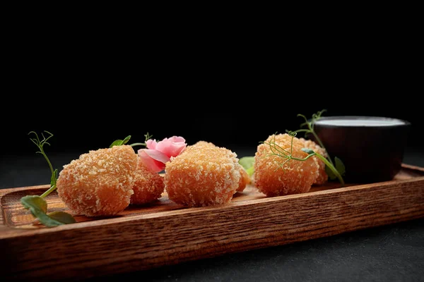 Camembert fries with sauce on a wooden board, on a dark background —  Fotos de Stock