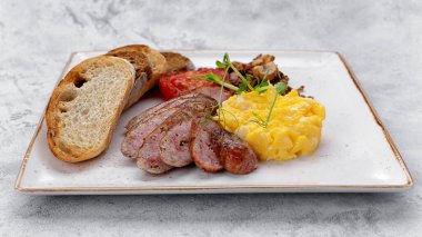 Tabakta İrlanda kahvaltısı. Sosis, omlet, mantar, pastırma, ciabatta tostu. Hafif bir arkaplanda