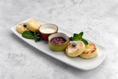 Kahvaltı, iki soslu peynirli kek ve yaban mersini.