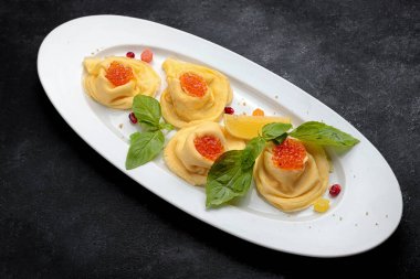 Beyaz tabakta kırmızı havyarlı geleneksel gözleme, fesleğen, koyu arkaplan