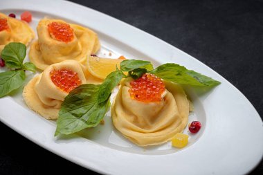 Beyaz tabakta kırmızı havyarlı geleneksel gözleme, fesleğen, koyu arkaplan