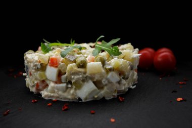 Siyah tahta üzerine salata Olivier, domatesli siyah arkaplan, yatay