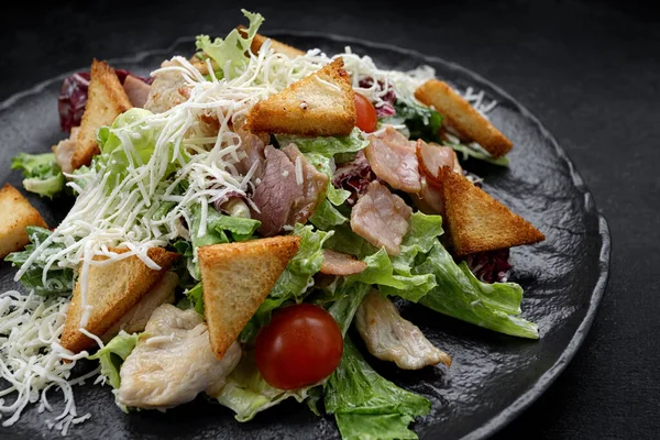 Caesar Salat Auf Schwarzem Teller Auf Schwarzem Hintergrund — Stockfoto