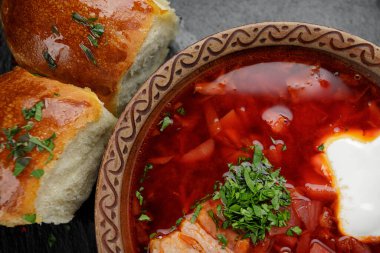 Kırmızı borş, sarımsaklı ve ekşi kremalı çörekler, koyu arkaplanda.