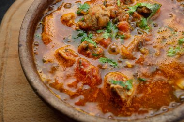 Gürcistan ulusal yemeği Ojakhuri, kilden bir tabakta, tahta bir tahtada, karanlık bir arka planda.