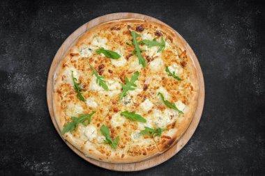 Dört peynirli pizza quattro fromaggi roka yapraklı gri beton üzerinde ahşap bir tahta üzerinde