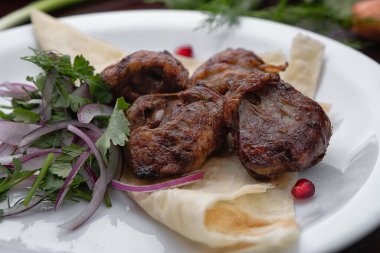 Lamb shish kebab with pita bread and herbs on a white plate selective focus