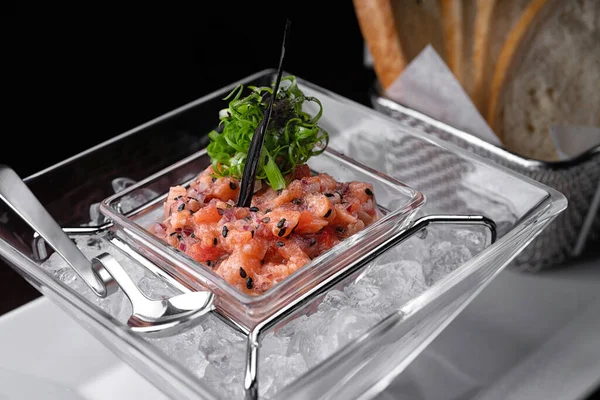 Salmon tartar in ice with toast in the background. selective focus