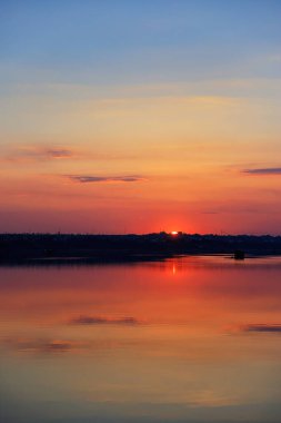Önünde bulutlar ve su olan güzel bir gün batımı